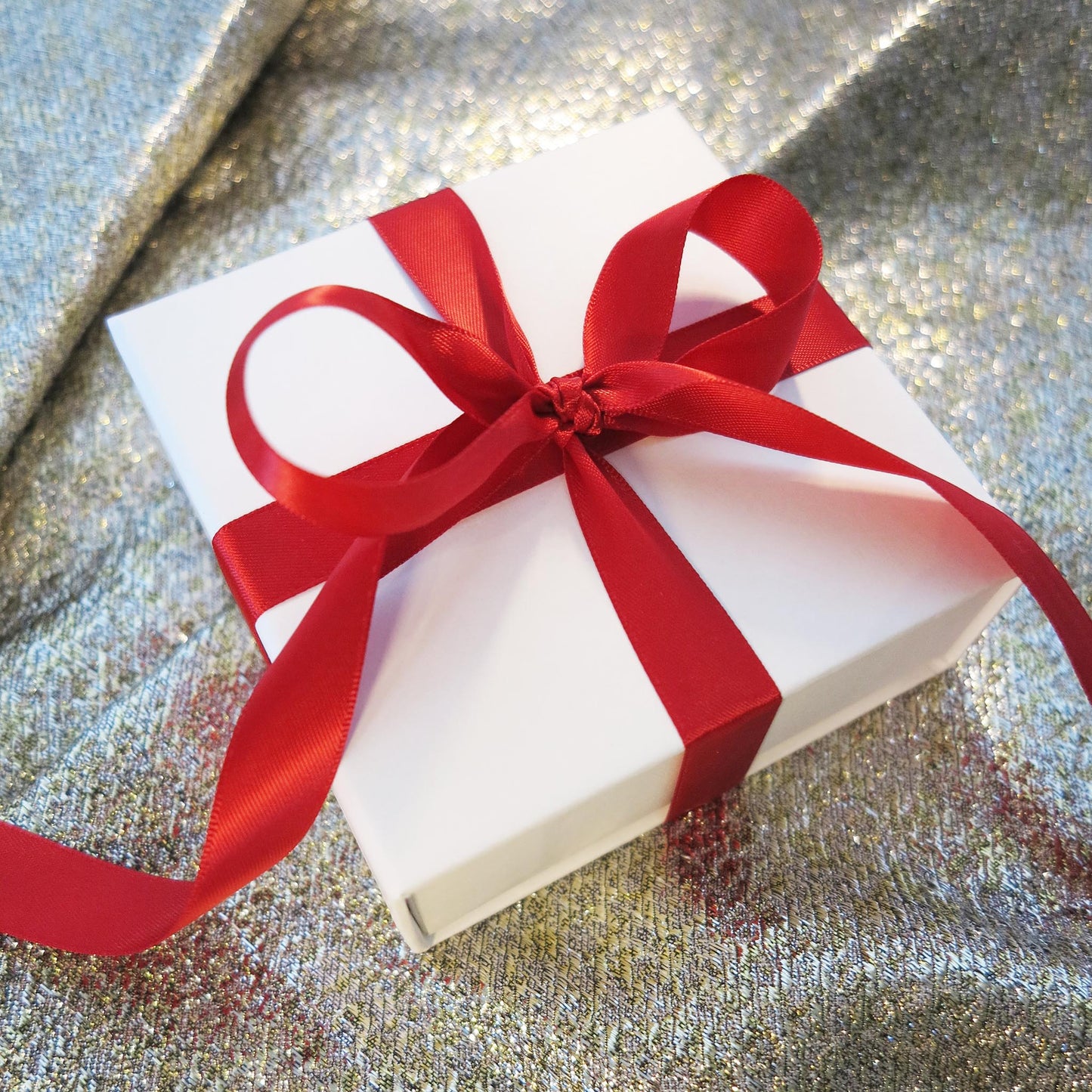 Delinor les carres collection holiday gift wrap white box with red ribbon