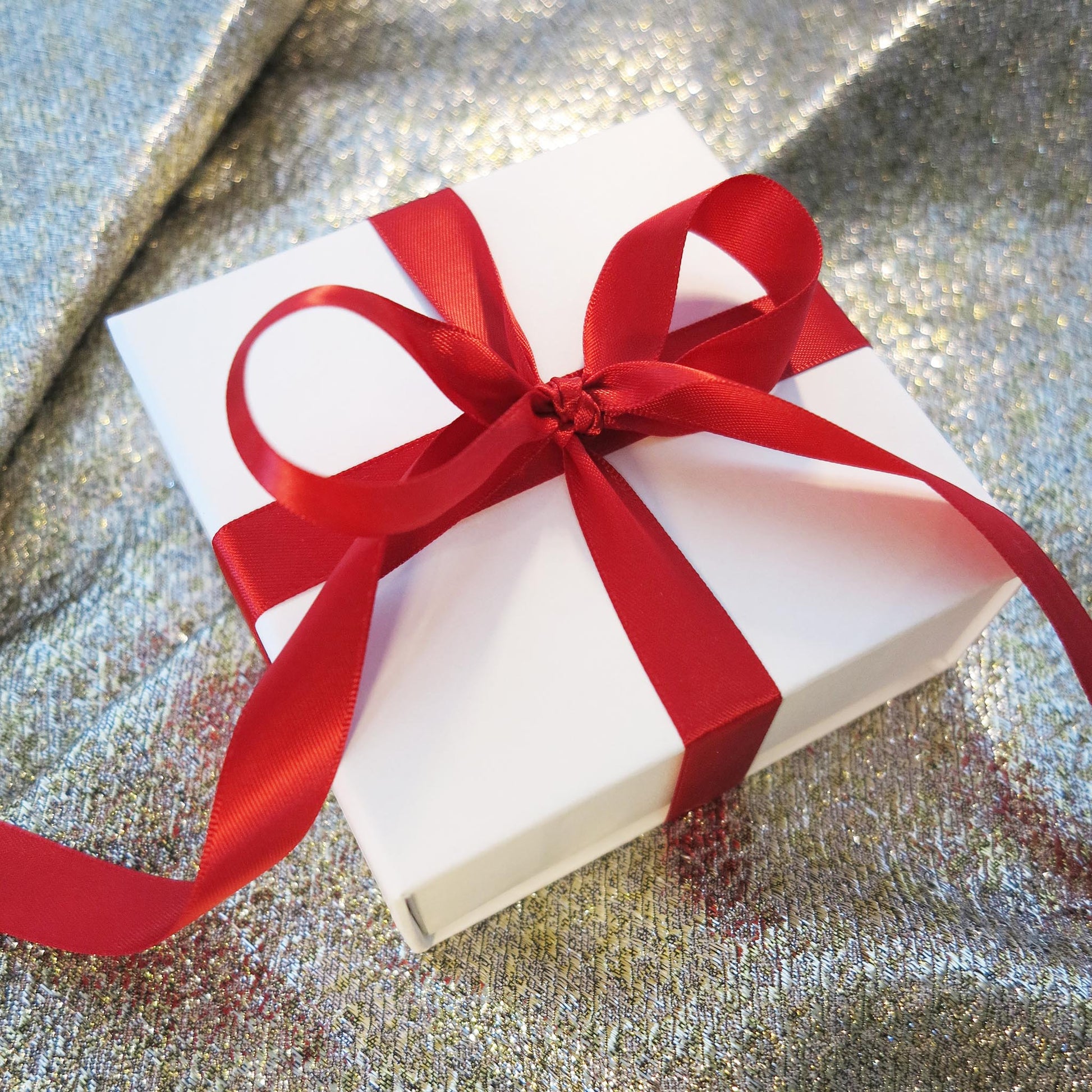 Delinor les carres collection holiday gift wrap white box with red ribbon